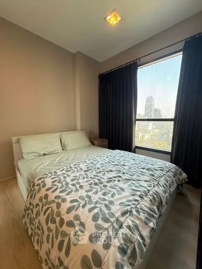 Cozy bedroom with city view, featuring modern decor and natural light.