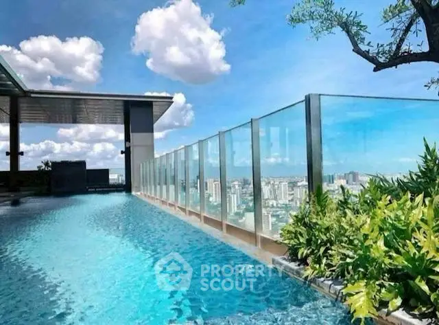 Luxurious rooftop pool with stunning city skyline view and modern glass railing.