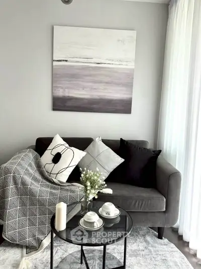 Cozy living room with modern decor, featuring a stylish sofa, elegant cushions, and a chic coffee table.