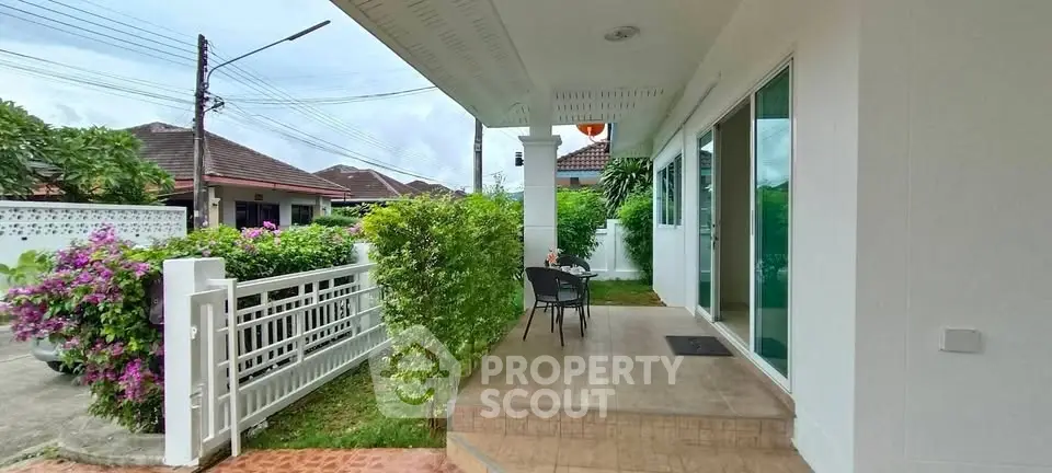 Charming suburban home with inviting front patio and lush greenery, perfect for relaxation.