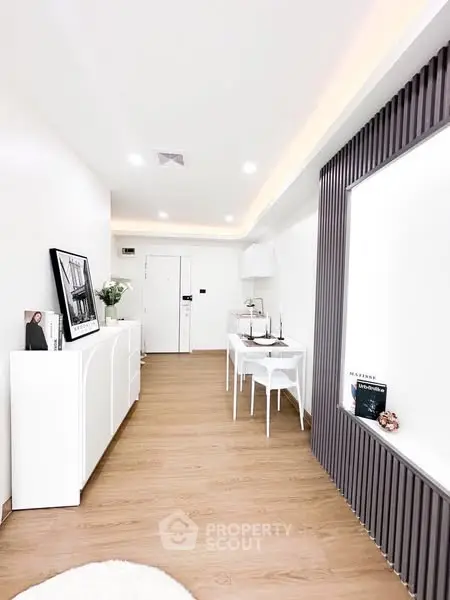 Modern minimalist living room with sleek white furniture and wooden flooring