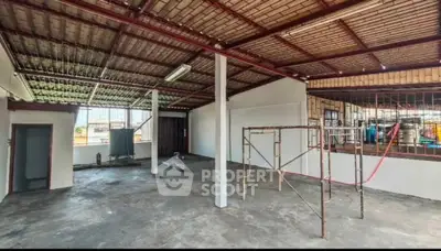 Spacious industrial-style open space with high ceilings and large windows, ideal for creative projects.
