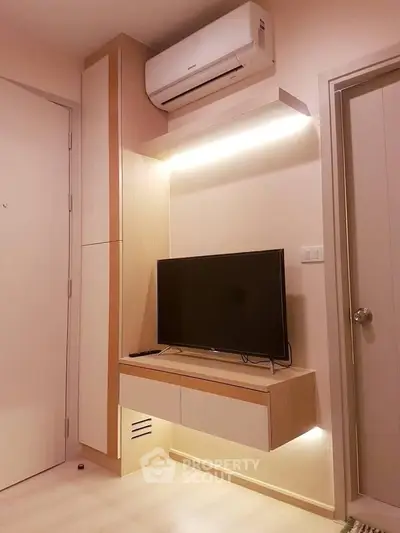 Modern living room with sleek TV setup and air conditioning unit, perfect for cozy relaxation.