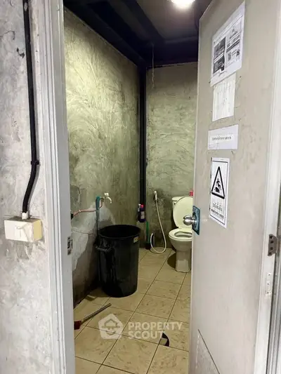 Industrial-style bathroom with concrete walls and basic fixtures
