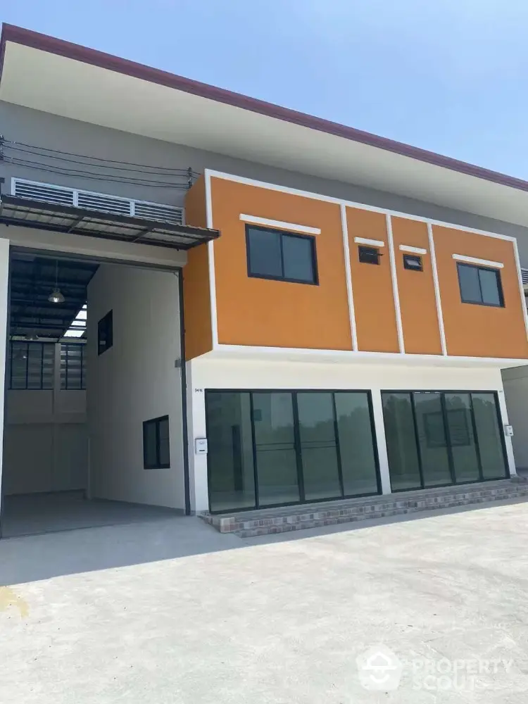 Modern commercial building with large glass windows and vibrant orange facade