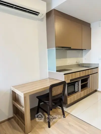 Modern kitchen with sleek cabinetry and compact dining area in a stylish apartment.