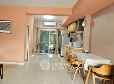 Spacious open-plan kitchen and dining area with modern furnishings and natural light.