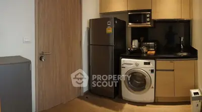 Compact modern kitchen with washing machine and stainless steel fridge
