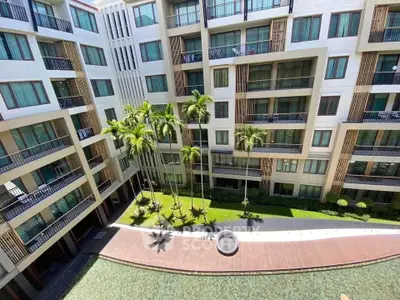 Modern apartment building with lush courtyard and pool view
