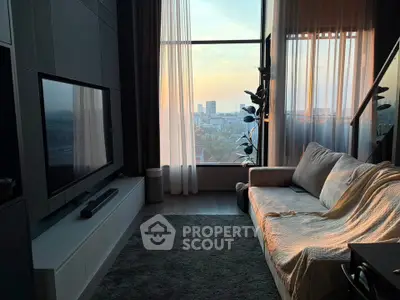 Modern living room with large window offering stunning city view at sunset