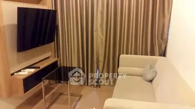 Cozy living room with modern sofa and wall-mounted TV, perfect for relaxation.