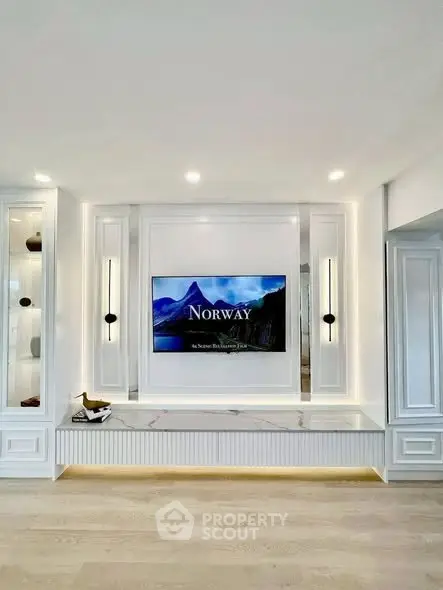 Luxurious living room with built-in TV and elegant lighting, showcasing modern design and sophistication.