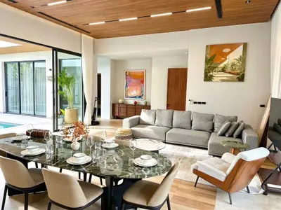 Luxurious open-plan living room with elegant dining area and pool view