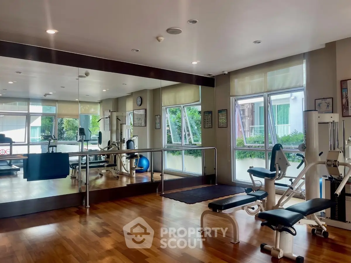 Spacious home gym with mirrored walls and modern fitness equipment.