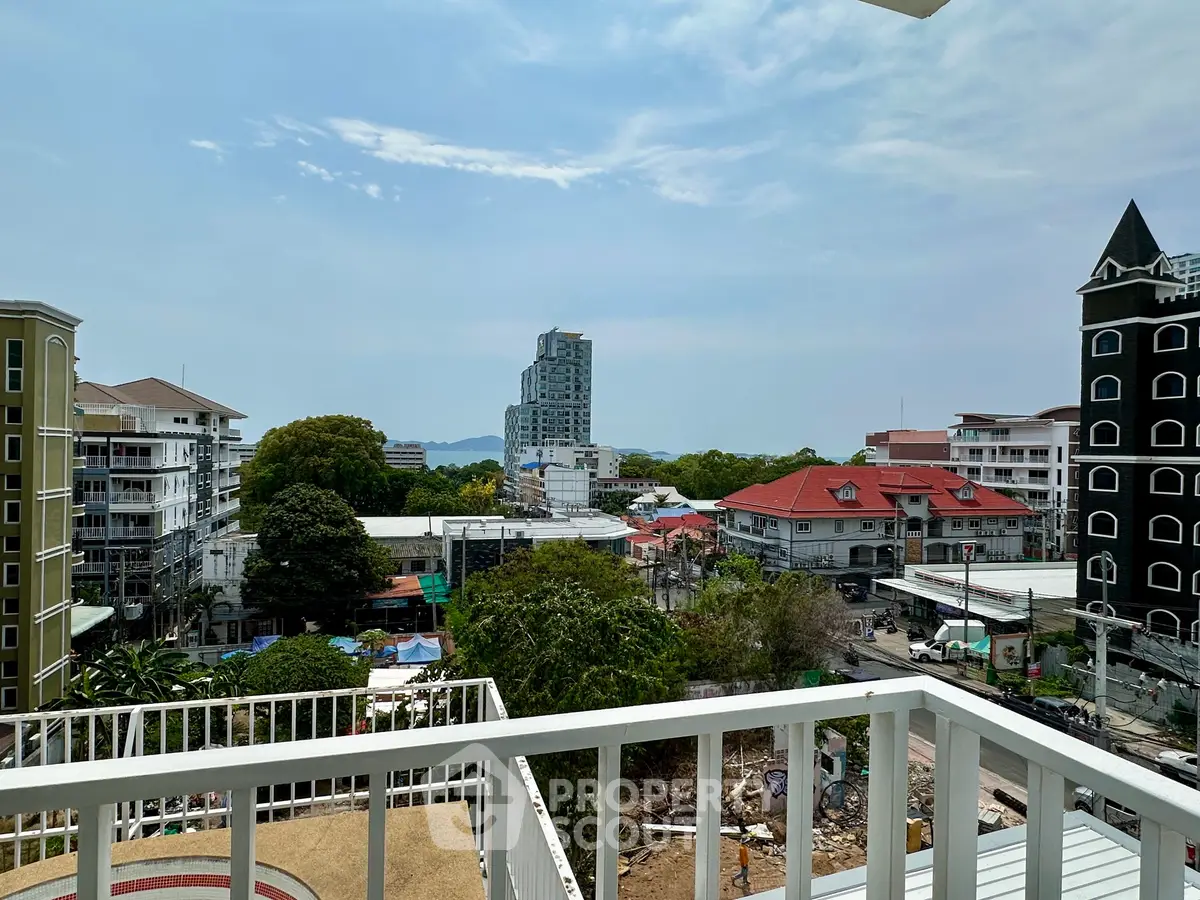 Stunning cityscape view from a spacious balcony overlooking urban skyline and lush greenery.