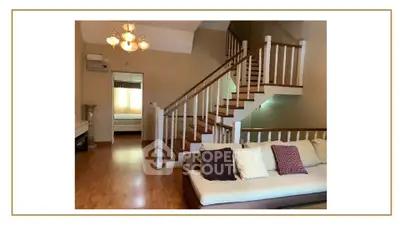Spacious living room with elegant staircase and cozy seating area in modern home.