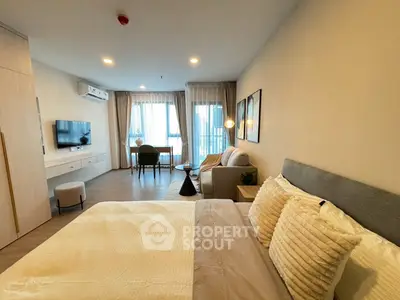 Modern bedroom with cozy seating area and large windows for natural light.