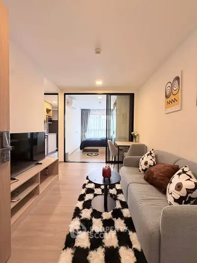 Modern living room with stylish decor and open view to bedroom