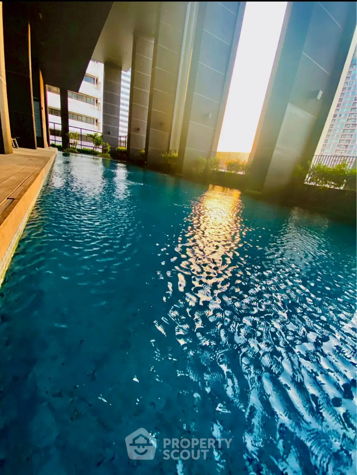 Luxurious high-rise building pool with stunning sunset view and modern architecture.