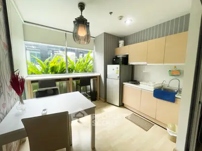 Modern kitchen with open layout, natural light, and stylish decor in a cozy apartment.