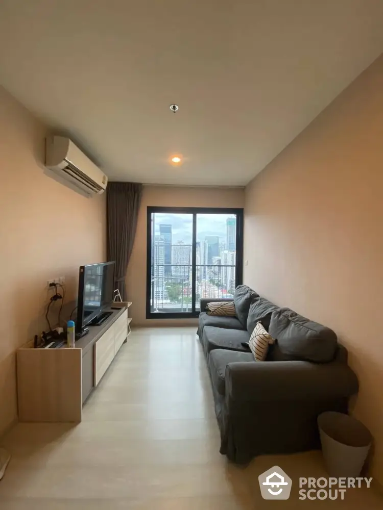 Modern living room with city view, featuring cozy sofa and entertainment setup.