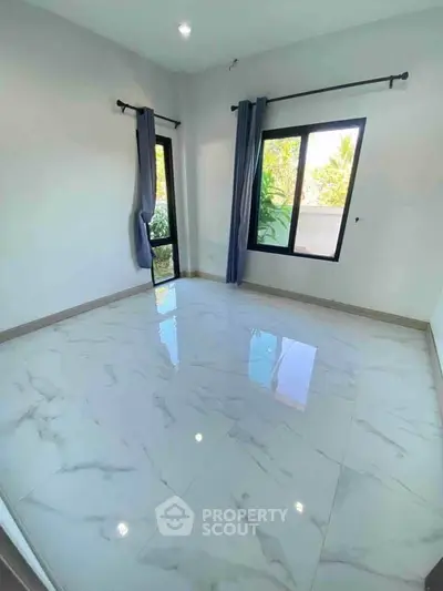 Bright empty room with large windows and marble flooring, perfect for customization.