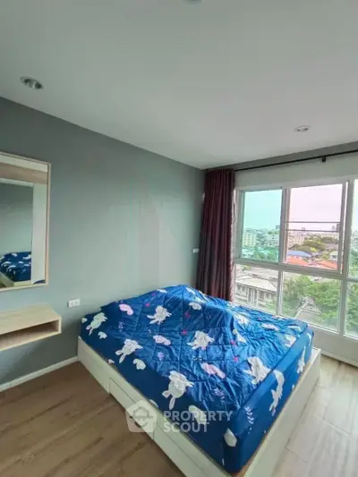 Bright bedroom with large window offering city views, featuring a cozy bed and modern decor.