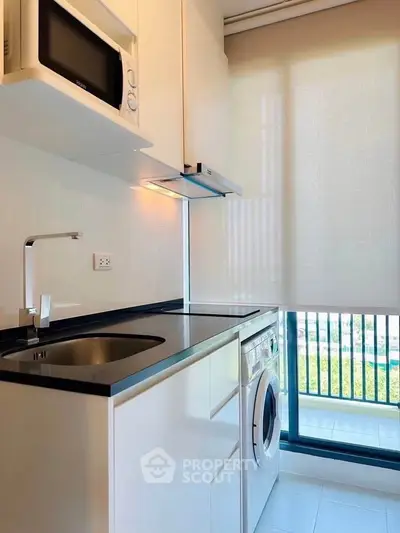 Modern kitchen with sleek appliances and large window view