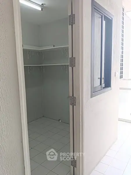 Spacious storage room with tiled floor and ample shelving in modern apartment.