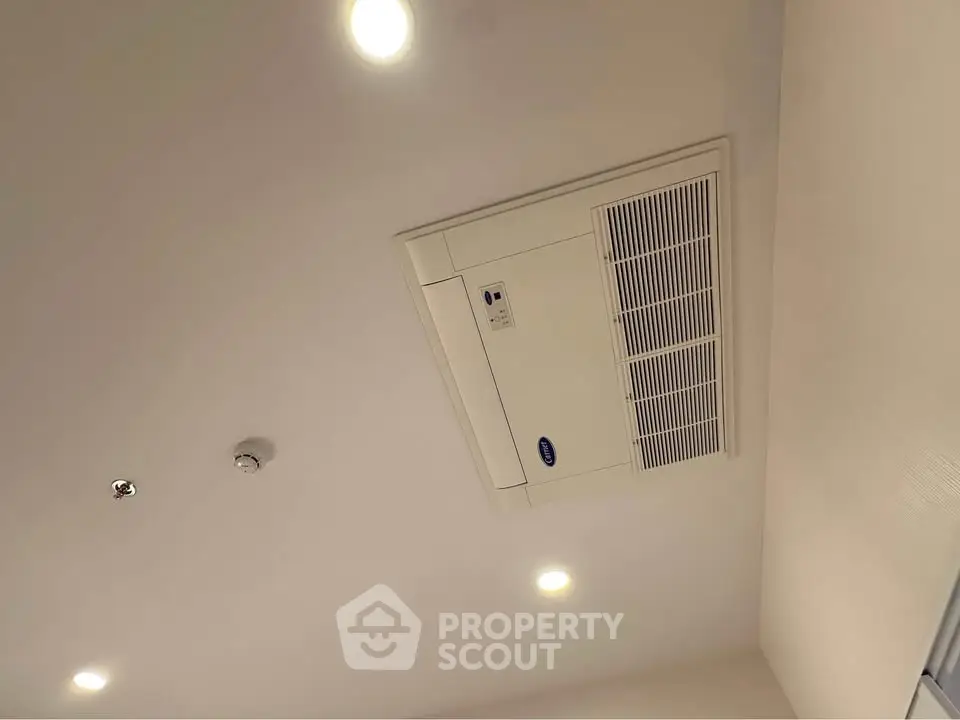 Modern ceiling with built-in air conditioning unit and recessed lighting.