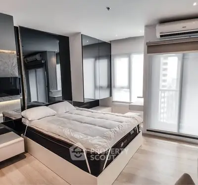 Modern bedroom with sleek design and large windows in a stylish apartment.