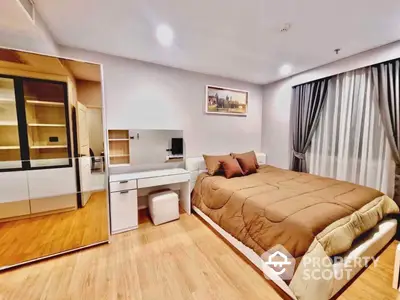 Spacious and modern bedroom with a large bed, mirrored wardrobe, and an integrated workspace, featuring sleek wooden flooring and contemporary lighting.