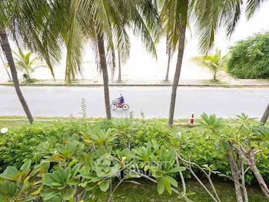Scenic view of a beachfront road lined with palm trees, perfect for serene living.