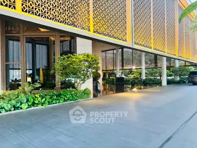Luxurious building entrance with modern design and lush greenery