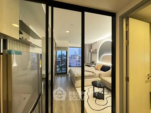 Modern studio apartment with cozy living area and city view balcony.