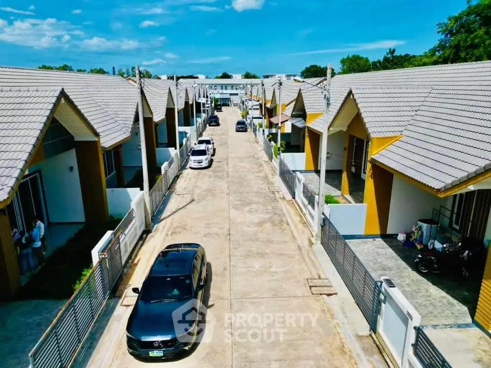 Charming residential community with modern townhouses and spacious driveways under a clear blue sky.