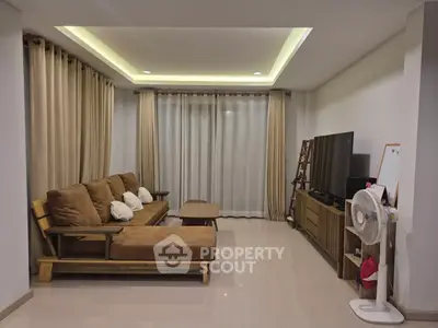 Spacious living room with modern furniture and large window, ideal for relaxation.