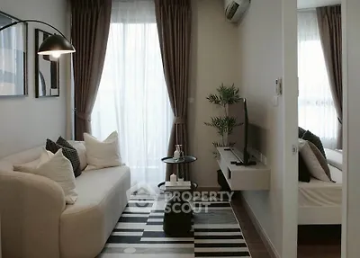 Cozy living room with modern decor and natural light, featuring a stylish sofa and TV setup.
