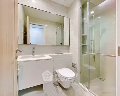 Modern bathroom with sleek fixtures and glass shower enclosure in a contemporary apartment.
