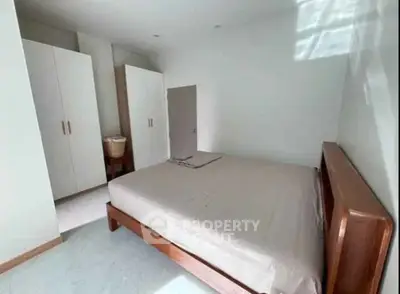 Spacious bedroom with wooden bed frame and ample closet space