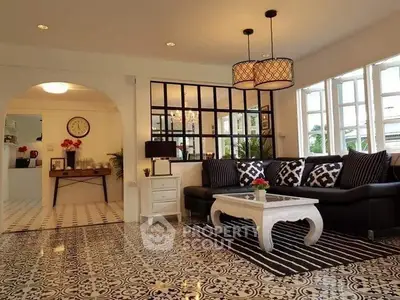 Charming living room with stylish decor, patterned floor tiles, and ample natural light.