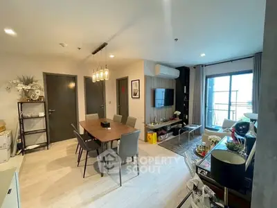 Modern living room with dining area and balcony access, featuring stylish decor and ample natural light.