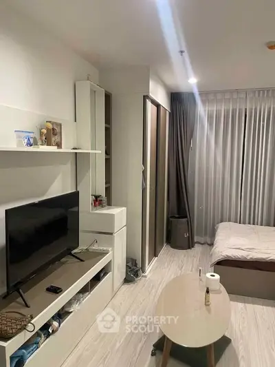Modern studio apartment with sleek design, featuring a cozy bed, TV unit, and stylish decor.