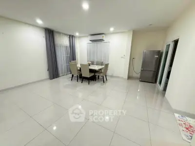 Spacious dining area with modern air conditioning and sleek tile flooring, perfect for family gatherings.