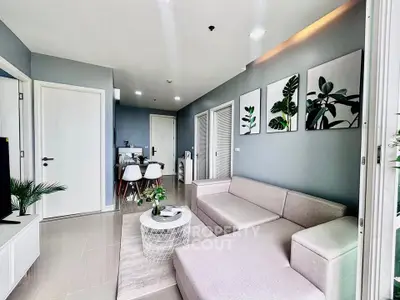 Modern living room with stylish decor and natural light, featuring a cozy sectional sofa and elegant dining area.