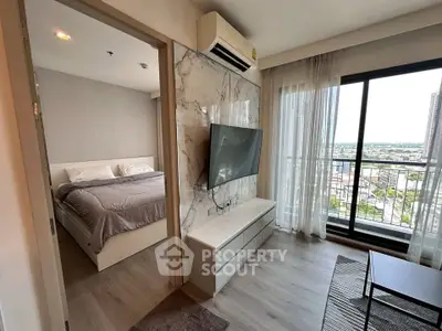 Modern apartment with bedroom and living area, featuring a balcony with city view.