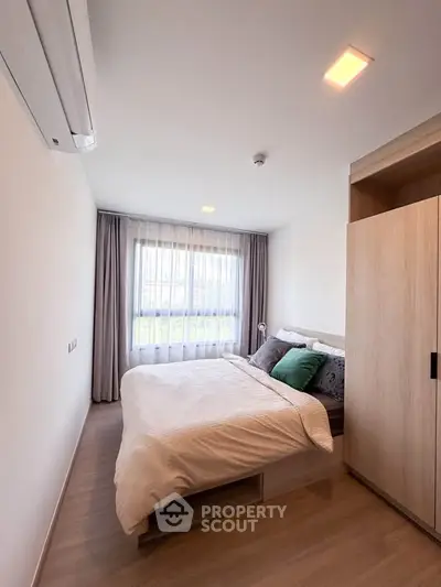 Modern bedroom with cozy bed and large window in stylish apartment