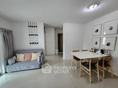 Modern living room with cozy sofa and dining area in open layout apartment.