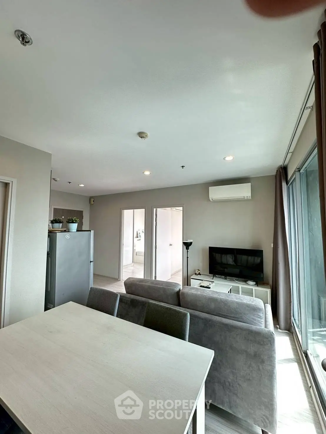 Modern living room with sleek furniture and large windows offering natural light.