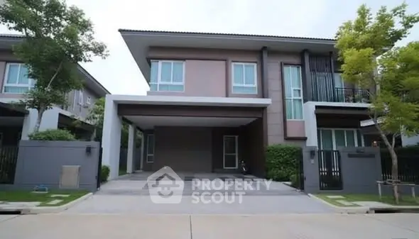 Modern two-story house with spacious driveway and lush greenery